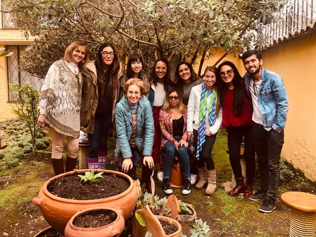 Grupo de estudiantes y docentes de un curso de Centir reunidos en el jardín del centro en Bogotá, Colombia